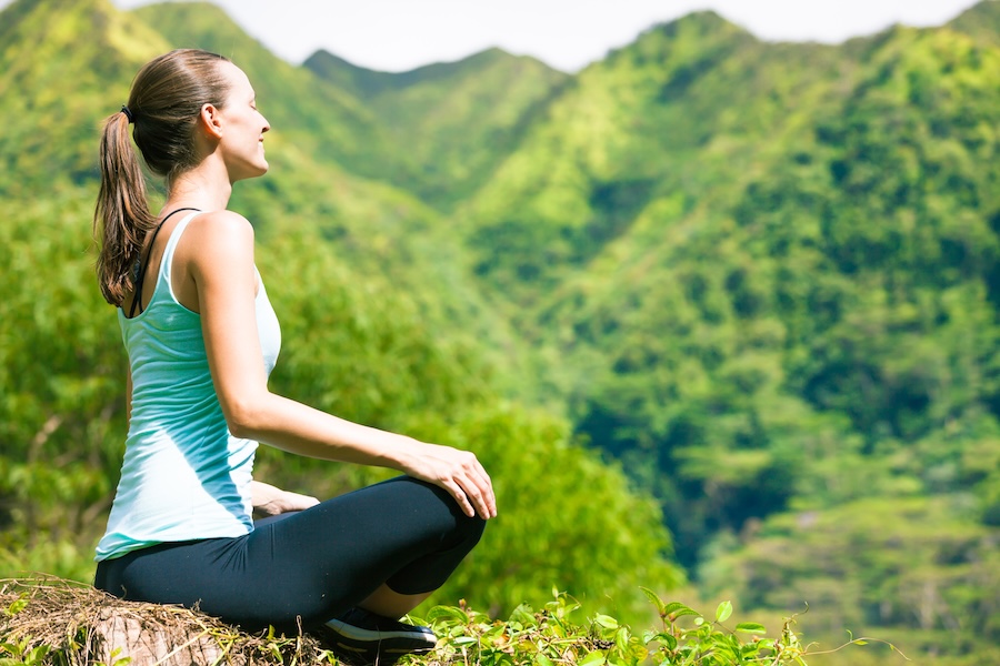 woman meditating outdoors in lush green mountains 2026 03 26 05 09 15 utc