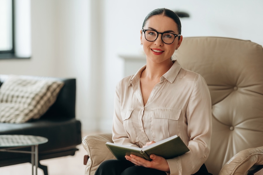 woman reading book in comfortable armchair at home 2026 03 20 04 01 01 utc